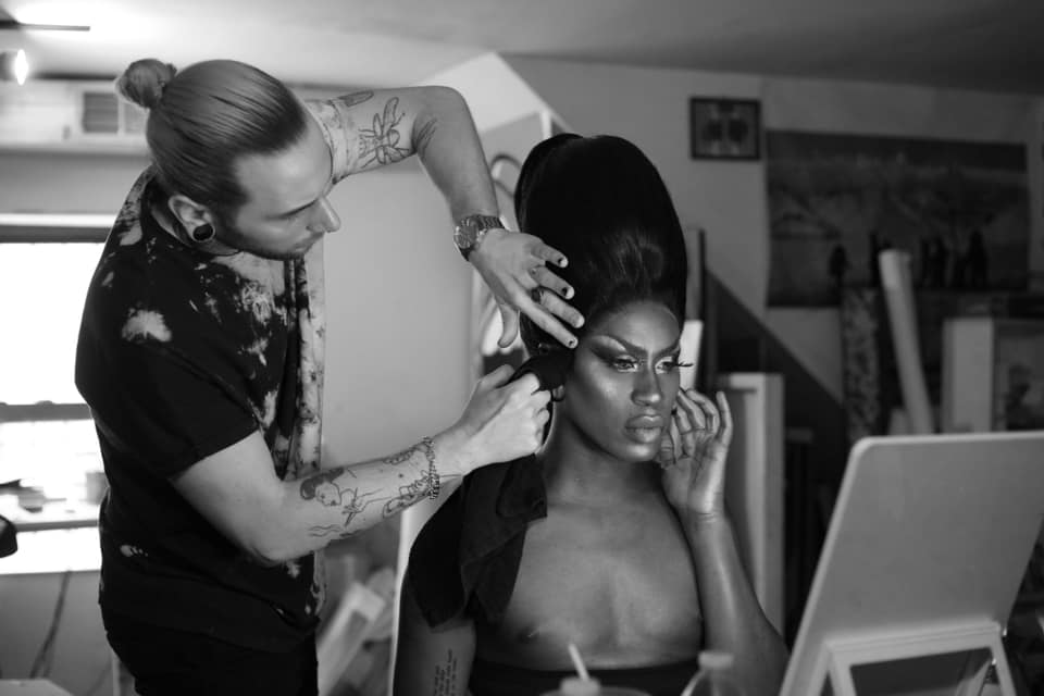 Jordan Phelps fixes the hair of artist Shea Couleé